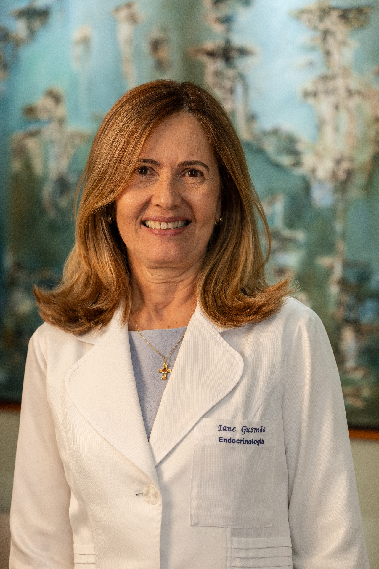 Dra. Iane Gusmão, endocrinologista, sorrindo com jaleco branco